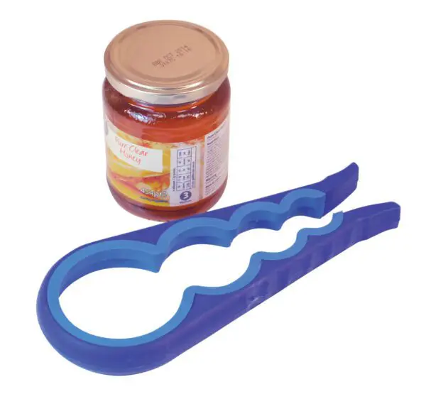 The Aidapt Universal 4-in-1 Jar and Bottle Opener in purple is placed next to a sealed glass jar of honey with a gold lid.