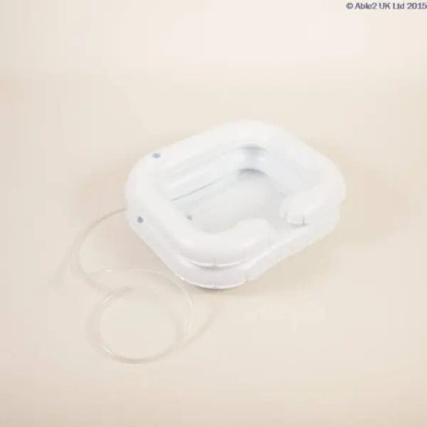 The ATLANTIS DELUXE INFLATABLE SHAMPOO RING is a white plastic basin with a drainage tube, designed for washing hair or other hygiene needs in bed.