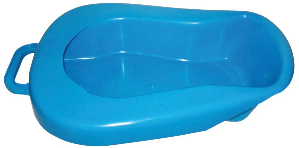 The Plastic Bedpan with Lid is a blue plastic bedpan featuring an integrated handle, ideal for bedbound patients or those with limited mobility.