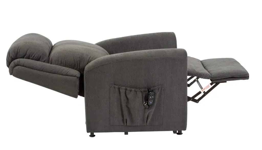 The Memphis Riser Recliner in grey upholstery is shown fully reclined, with its footrest extended and a side pocket holding a remote control.