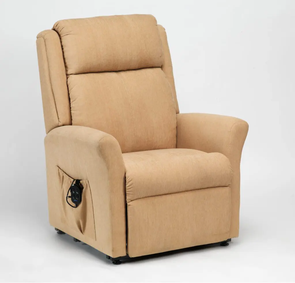 The Memphis Riser Recliner is a beige upholstered chair with padded arms and headrest, featuring a remote control stored in a side pocket, set against a plain white background.
