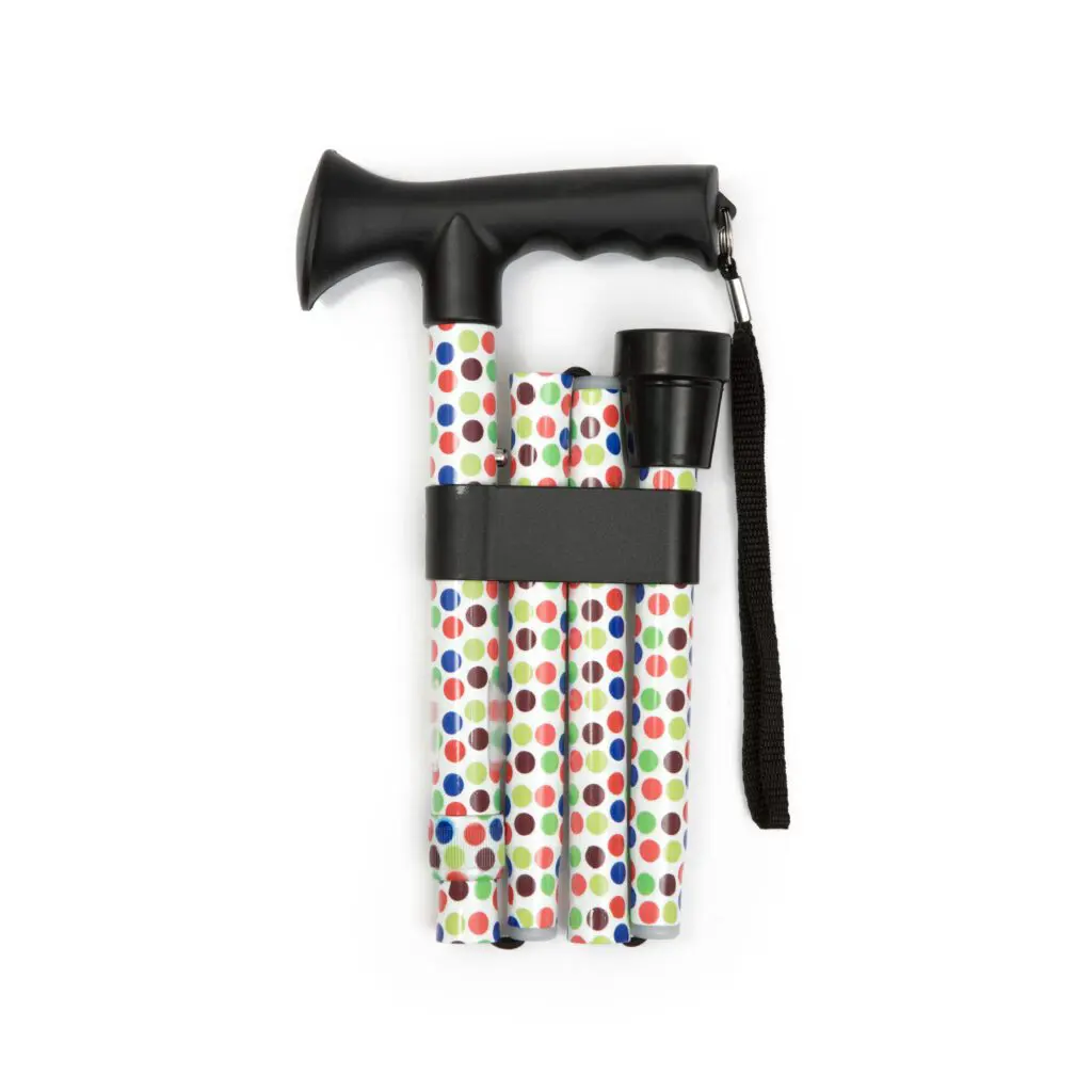 Petite Walking Sticks: A folded walking stick featuring a black handle, colourful polka dot pattern, and secured with a black strap and wrist loop.