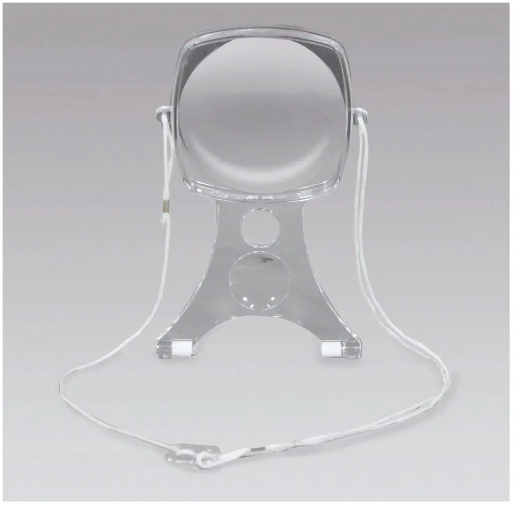 The Handsfree Craft Magnifier, made of clear acrylic with a stand and a white neck cord, displayed on a plain grey background.