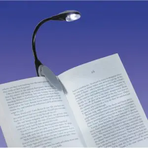 An LED Clip Light is attached to an open book, brightly illuminating its pages against a smooth gradient blue background.