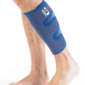A person wearing the NEO G CALF/SHIN SPLINT SUPPORT on their lower leg stands barefoot against a white background.