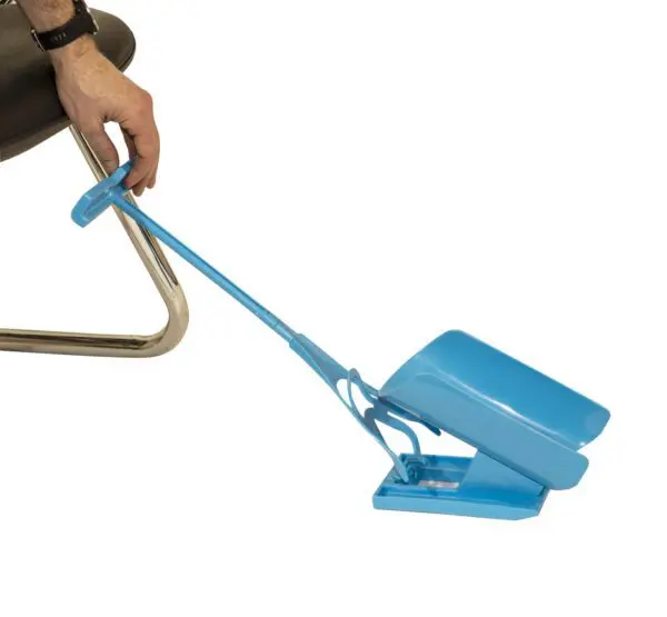 A person uses a Sock Aid Slider whilst seated on a chair.