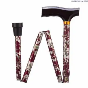 A folding walking stick with a dark T-shaped handle and burgundy floral pattern, shown in its folded position with rubber tip visible.