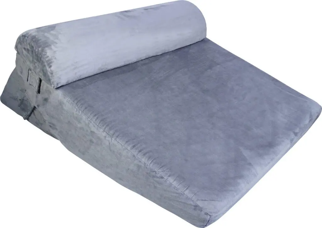 The Luxury Folding Adjustable Bed Wedge Pillow is grey, wedge-shaped with a soft fabric cover and attached bolster, designed for comfortable support and elevation.