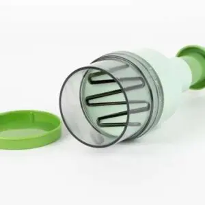 A green and clear plastic food chopper with metal blades sits beside its matching green lid on a white background.