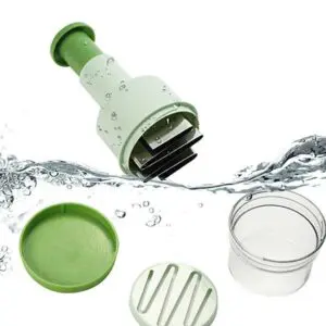 The Food Chopper, in green and white, is displayed with its parts disassembled—lid, round container, and slicing insert—whilst water splashes around them.