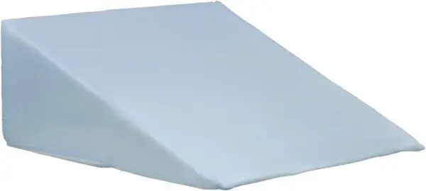 The Bed Wedge Cushion is a light blue, wedge-shaped pillow with a fabric cover, designed to provide support or elevation whilst lying down or sitting.