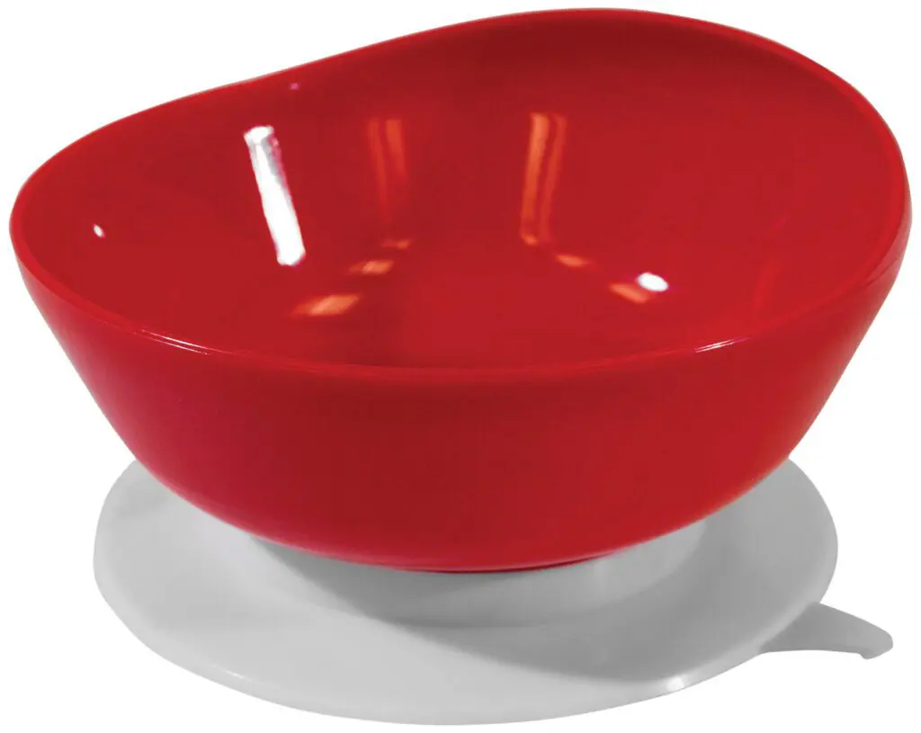 A red plastic bowl with an uneven rim sits on a round white base against a white background.