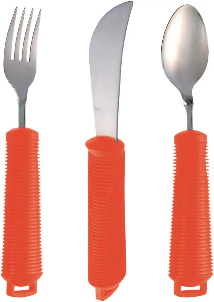 The Bendable Cutlery Set (6 piece) in red features a fork, knife, and spoon with wide, textured handles arranged upright against a white background.
