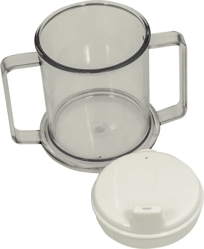 Two-handled drinking cup made of clear plastic, displayed beside a white plastic lid featuring a small spout.