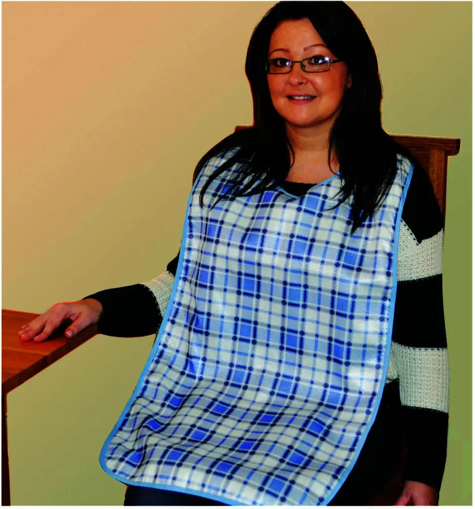 A woman sits at a table wearing an Adult Dining Bib in blue and white check over a black and white striped jumper.