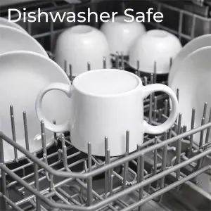 A white double-handled cup sits upright in a dishwasher rack among plates and bowls. The text “Dishwasher Safe” appears at the top.