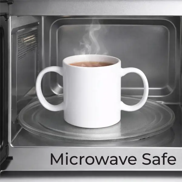 A white mug with two handles sits on a glass turntable inside a microwave, with steam rising. The words "Microwave Safe" are written at the bottom.