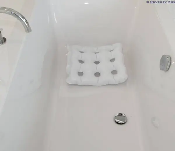 An Inflatable Bath Cushion with suction cups is positioned at the bottom of a clean white bath.