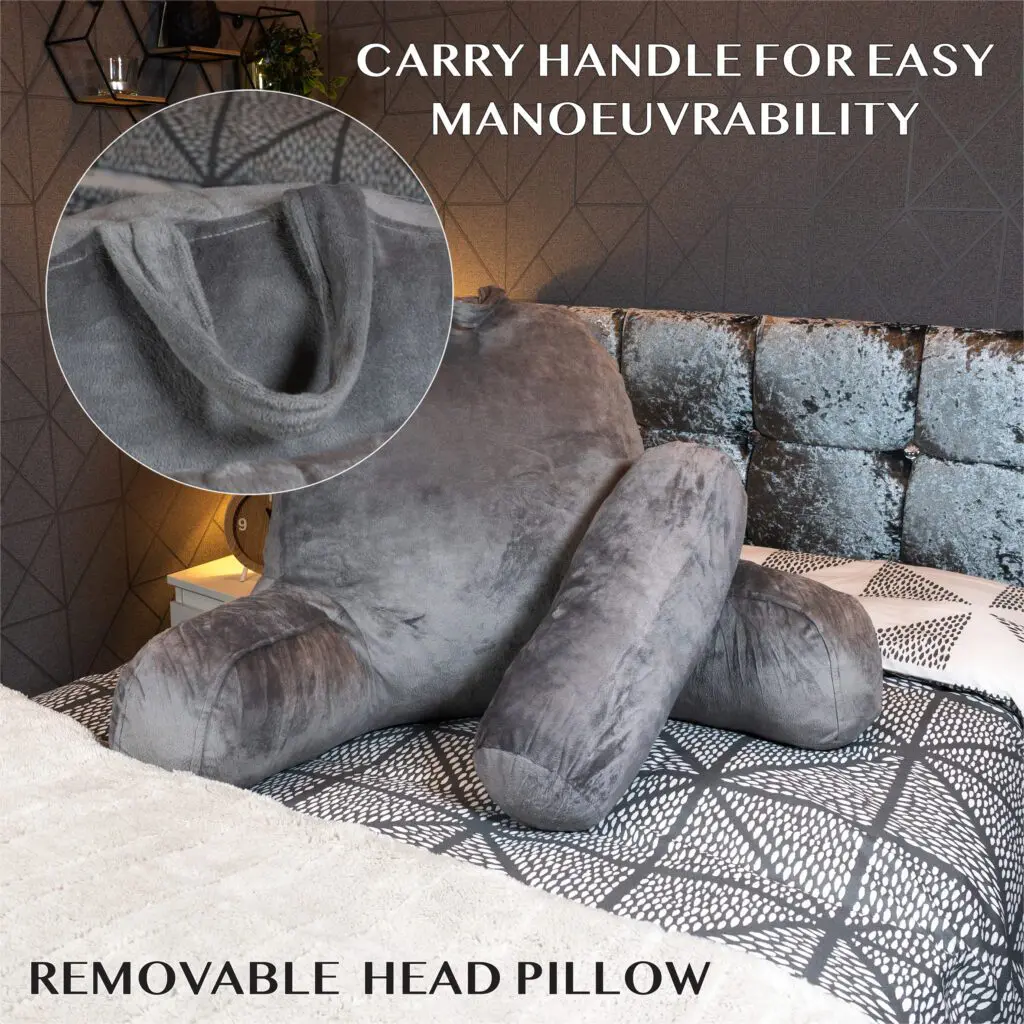 The Reading Pillow with Head Rest and Back Support sits on a bed, showcasing armrests, a convenient carry handle for easy manoeuvrability, and a removable head pillow.