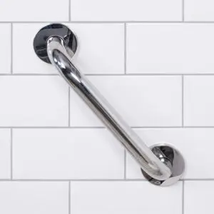A stainless steel grab rail in a polished finish is mounted diagonally on a white tiled wall.