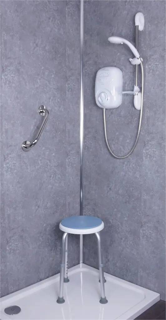 Accessible shower featuring a polished stainless steel grab rail, electric shower unit, handheld showerhead, and a small stool with a blue seat.
