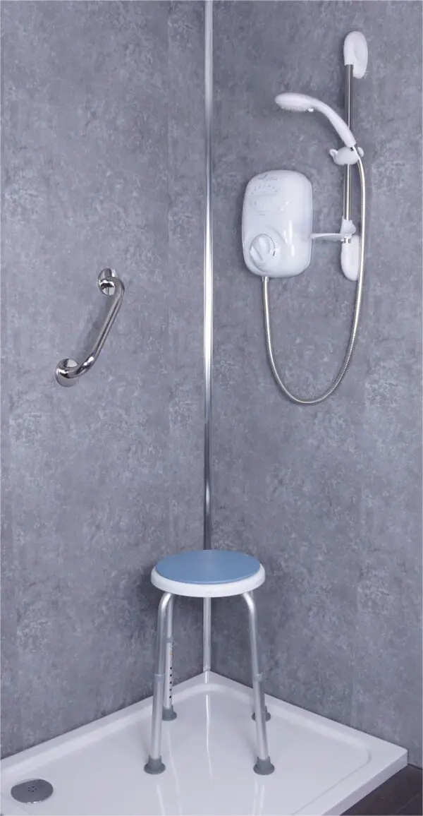 Accessible shower featuring a polished stainless steel grab rail, electric shower unit, handheld showerhead, and a small stool with a blue seat.