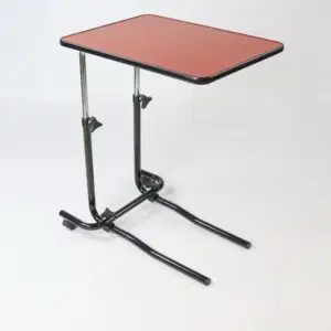The Economy Over Bed Table is a small, rectangular table with an adjustable height, a red tabletop, and a black metal frame. It’s designed to slide under furniture for convenient use as a tray or work surface.
