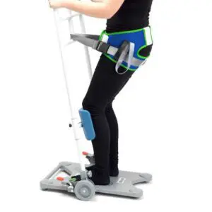 A person using Patient Turner Belts with a harness and handlebars for support, standing on a wheeled platform.