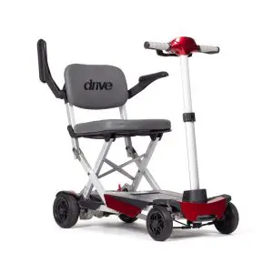 Manual Fold+ foldable mobility scooter featuring a grey seat, black armrests, four wheels, and red accents, displayed upright against a white background.