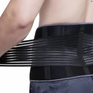 A person wearing and adjusting the Aero-Tech Neoprene Advanced Back Support - Universal around their lower back, pulling the straps for a snug fit.