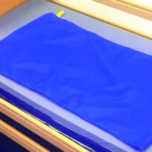 A blue Reusable Tubular Slide Sheet lying flat on a hospital bed mattress.