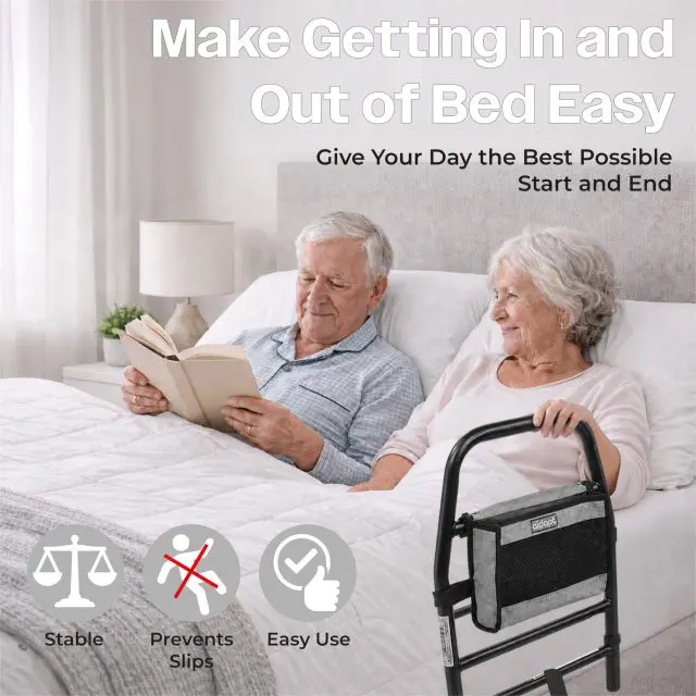 An elderly couple sits in bed reading, with a black Solo Bed Transfer Aid, Black featuring a storage pouch positioned at the bedside; includes text icons for stability, slip prevention, and easy use.