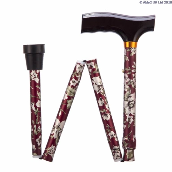 A folding walking stick with a dark T-shaped handle and burgundy floral pattern, shown in its folded position with rubber tip visible.