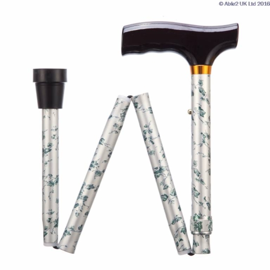 Folding walking stick with a dark handle and a light-coloured shaft featuring a green floral pattern, shown in a partially folded position.