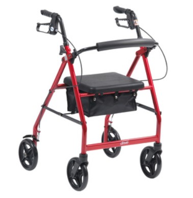 A red four-wheeled rollator with hand brakes, a black padded seat, and a storage pouch underneath.