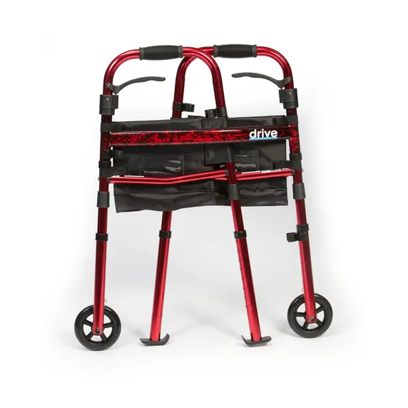 The Ready Set Go Travel Walker, featuring a red foldable frame, two front wheels, foam hand grips, and a black storage pouch, is shown standing upright against a plain white background.