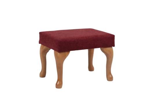 Small wooden stool with four curved legs and a rectangular, red cushioned seat. The stool is set against a plain white background.