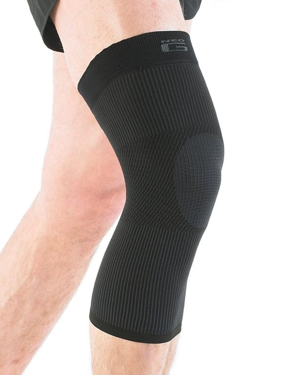 A person wearing a black knee support on their left leg, shown from mid-thigh to mid-calf against a white background.