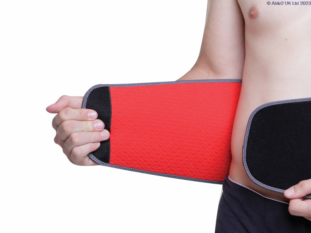 A person wearing the Aero-Tech Neoprene Advanced Back Support - Universal, fastening it around their waist with one hand, against a white background.