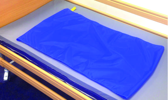 A blue Reusable Tubular Slide Sheet lying flat on a hospital bed mattress.